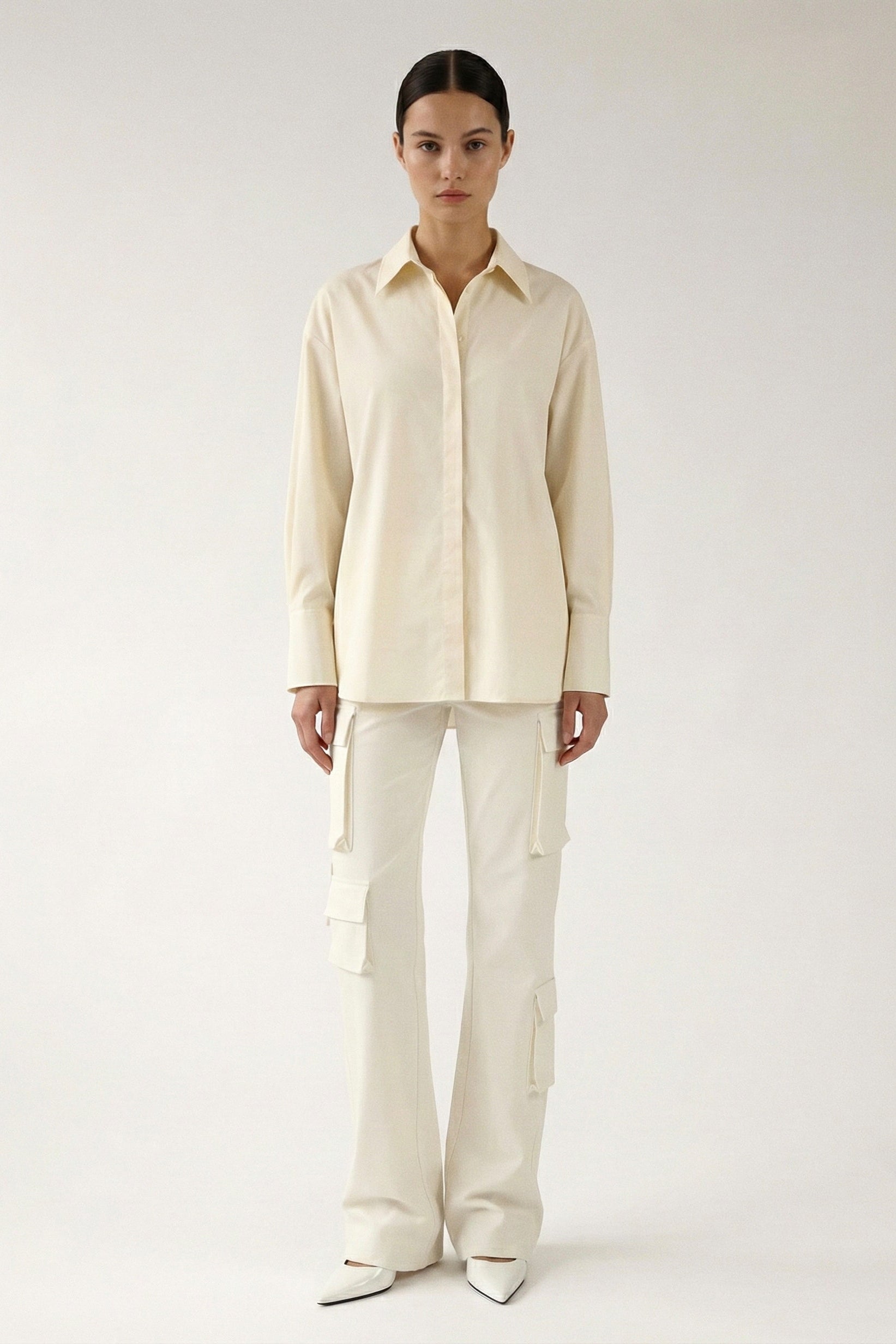 Person wearing a cream-colored shirt and pants on a white background