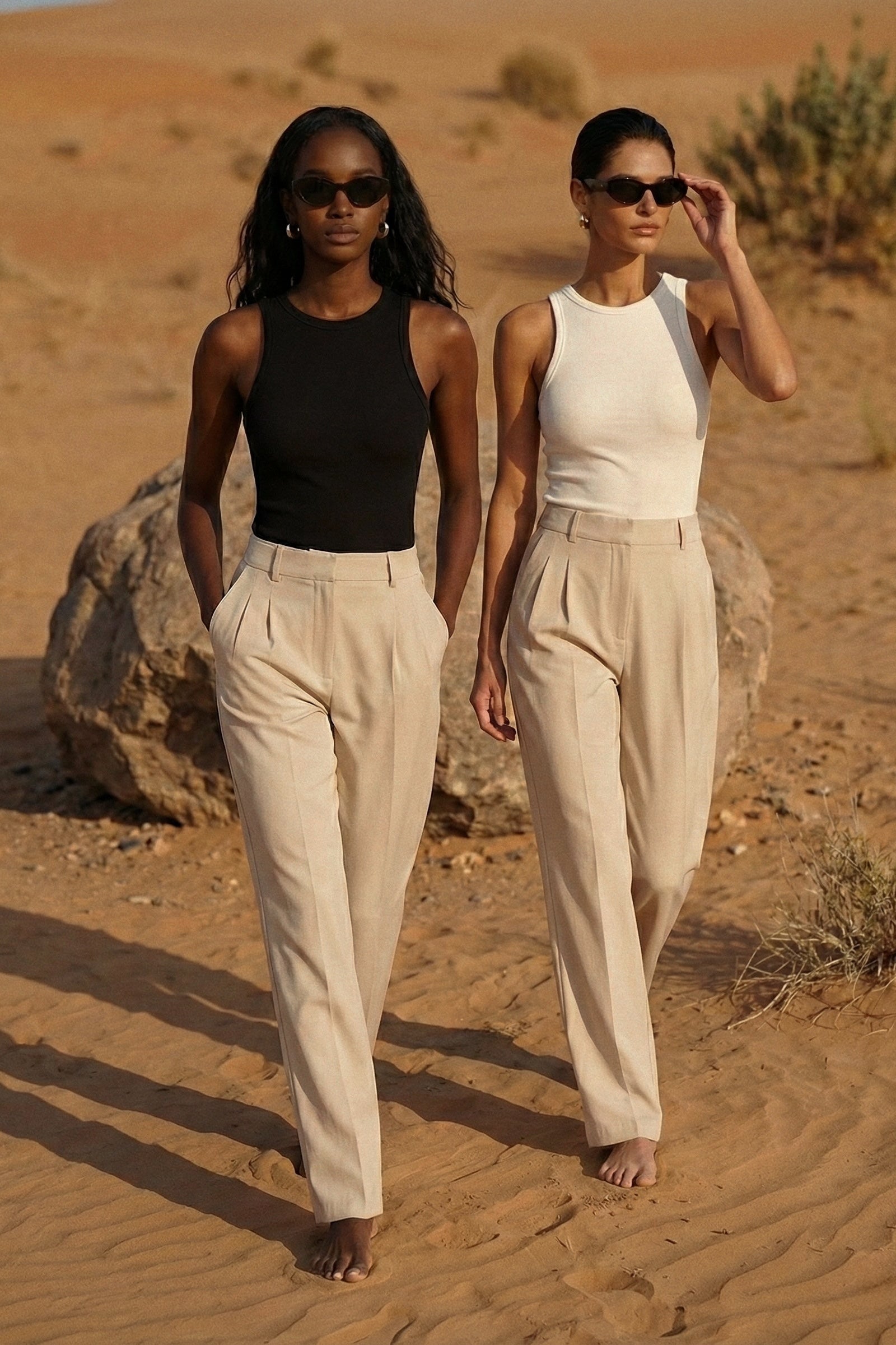 Two women walking in the desert wearing matching outfits.