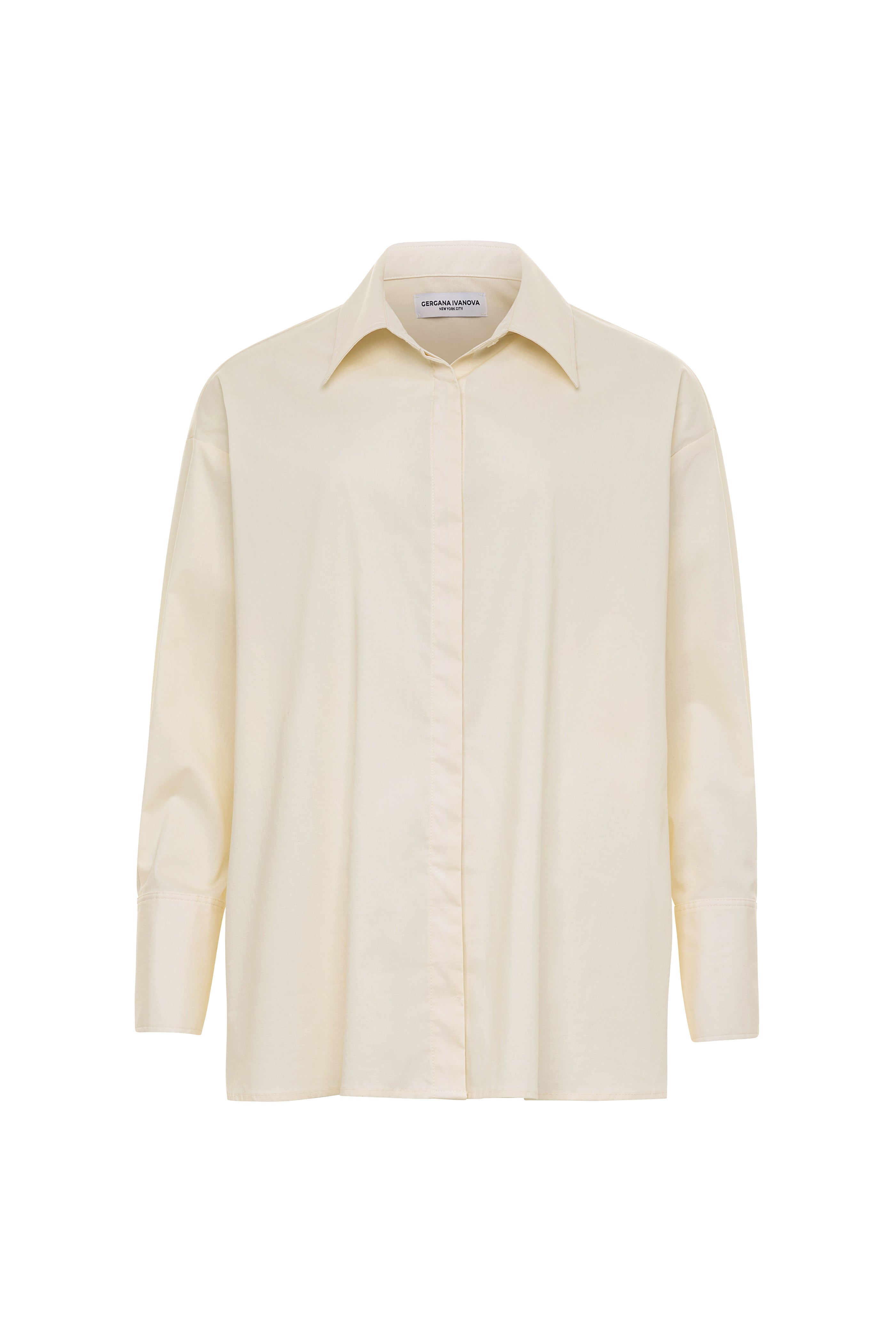 A beige, long-sleeved, button-down shirt with a pointed collar and button cuffs, displayed on a white background.